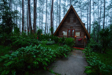 A frame triangle holiday house in the woods at night, peaceful weekend getaway in nature