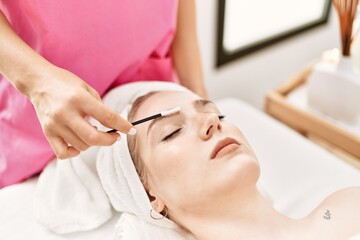 Obraz na płótnie Canvas Woman reciving eyebrows treatment at beauty center.