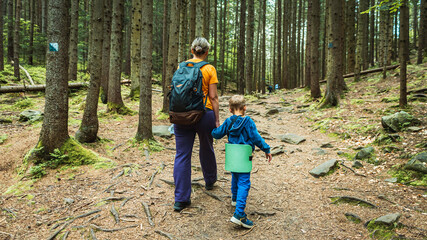 Mother and son climbed a mountain in the woods. Spring day. Camping, family travel concept. Mountaineering, family travel. Selective focus.