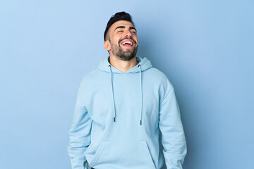 Caucasian man over isolated blue background laughing