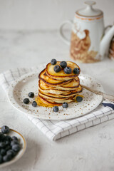 Breakfast with pancakes and berries on a white background, vertical photo