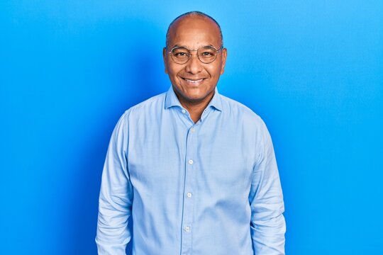 Middle age latin man wearing casual clothes and glasses with a happy and cool smile on face. lucky person.