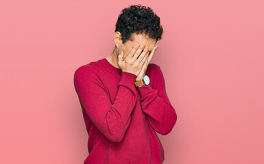 Young handsome man wearing casual clothes with sad expression covering face with hands while crying. depression concept.