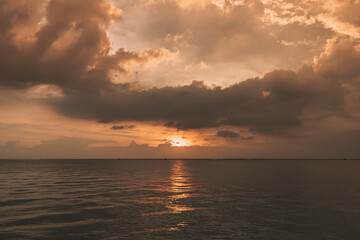 Naklejka na ściany i meble Calm sunset ocean with stormy cloud in the sky.