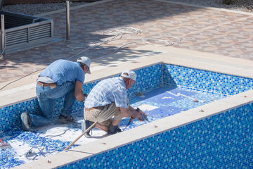 Two men working on swimming pool - Alanya, Turkey - May 18, 2021 - obrazy, fototapety, plakaty