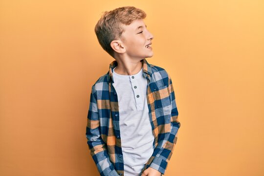 Little Caucasian Boy Kid Wearing Casual Clothes Looking Away To Side With Smile On Face, Natural Expression. Laughing Confident.