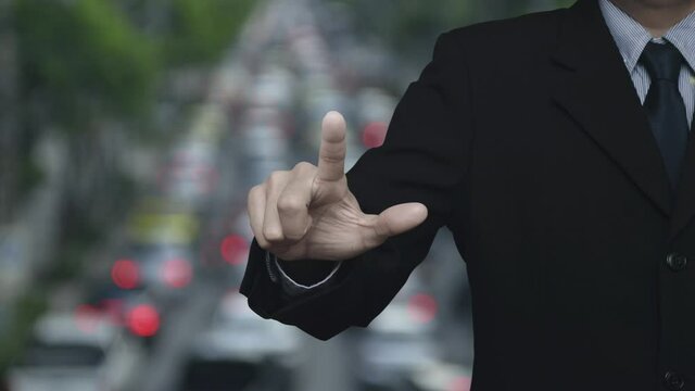 Businessman pressing map pin point location button over blur of rush hour with cars and road in city, Map pointer navigation online concept
