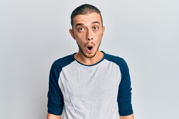 Hispanic young man wearing casual clothes afraid and shocked with surprise expression, fear and excited face.