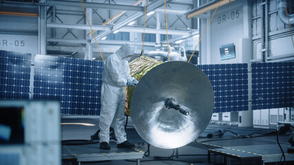 Engineer in Protective Suit Working on Satellite Construction. Aerospace Agency Manufacturing Facility: Scientists Developing Spacecraft for Space Exploration, Communications, Cosmos Observation  © Gorodenkoff