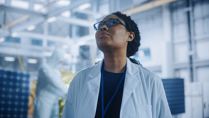Brilliant Female Engineer Looking Around in Wonder at the Aerospace Satellite Manufacturing Facility. Young Talent Starting Her Career in World Top Science and Technology Space Exploration Program