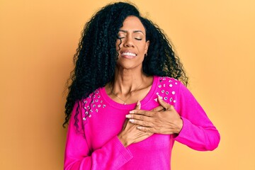 Middle age african american woman wearing casual clothes smiling with hands on chest, eyes closed with grateful gesture on face. health concept.