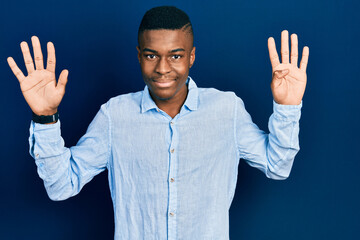 Young african american man wearing casual clothes showing and pointing up with fingers number nine...