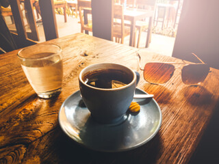 Coffee cup sunglasses and water and wooden table, the perfect break