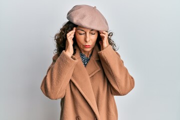 Middle age hispanic woman wearing french look with beret with hand on head for pain in head because stress. suffering migraine.