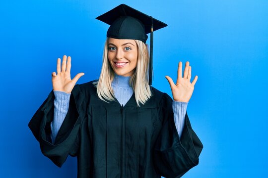 Beautiful blonde woman wearing graduation cap and ceremony robe showing and pointing up with fingers number nine while smiling confident and happy.