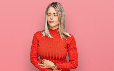 Beautiful blonde woman wearing casual clothes with hand on stomach because indigestion, painful...