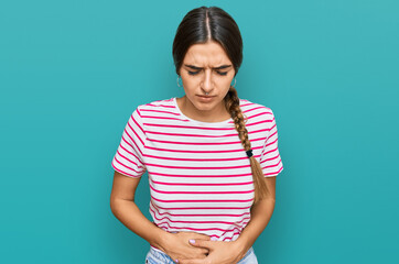 Obraz premium Young hispanic woman wearing casual clothes with hand on stomach because indigestion, painful illness feeling unwell. ache concept.