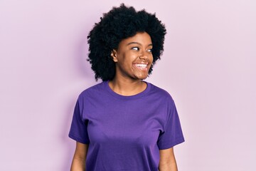 Fototapeta na wymiar Young african american woman wearing casual clothes looking away to side with smile on face, natural expression. laughing confident.