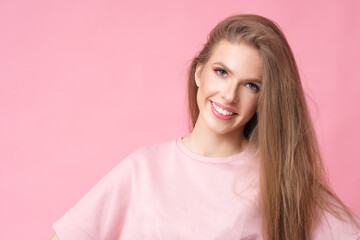 Positive long hair woman on pink background.