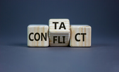 Conflict or contact symbol. Turned the wooden cube and changed the word 'conflict' to 'contact'. Beautiful grey background, copy space. Business, conflict or contact concept.