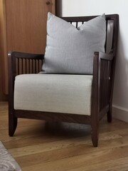 Old restored armchair with gray upholstery and pillow.
