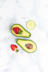 Avocado cut half and slice with strawberry. Detox concept. vertical image. top view