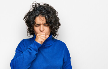 Fototapeta na wymiar Young hispanic woman with curly hair wearing turtleneck sweater feeling unwell and coughing as symptom for cold or bronchitis. health care concept.