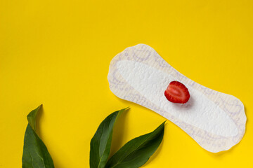 Feminine hygiene panty liner for menstruation. Menstrual cycle, pad. Yellow background. red strawberry.