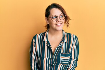 Young caucasian woman wearing casual clothes and glasses smiling looking to the side and staring away thinking.