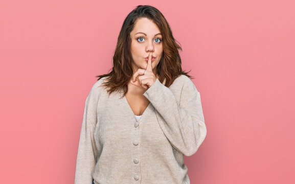 Young plus size woman wearing casual clothes asking to be quiet with finger on lips. silence and secret concept.