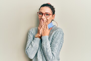 Young caucasian woman wearing casual clothes and glasses laughing and embarrassed giggle covering...