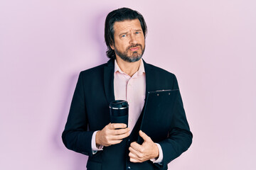 Middle age caucasian man wearing business clothes drinking a take away cup of coffee depressed and worry for distress, crying angry and afraid. sad expression.