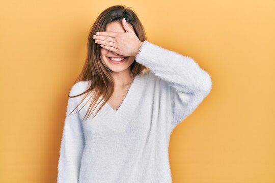 Young caucasian girl wearing casual clothes smiling and laughing with hand on face covering eyes for surprise. blind concept.