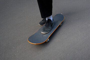 A young man rides a skateboard in the park in the summer.
