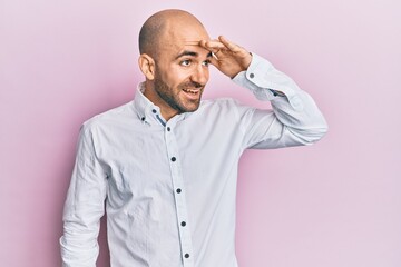 Fototapeta premium Young hispanic man wearing casual clothes very happy and smiling looking far away with hand over head. searching concept.