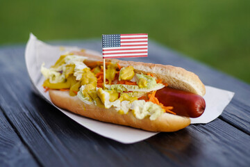 American patriotic hot dog on wooden board with USA flag. Celebrating Independence day on 4th July in United States of America
