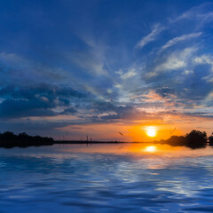 Obraz premium dramatic sunset reflected in quet lake, countryside natural sunset background