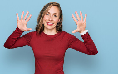 Young blonde woman wearing casual clothes showing and pointing up with fingers number ten while smiling confident and happy.