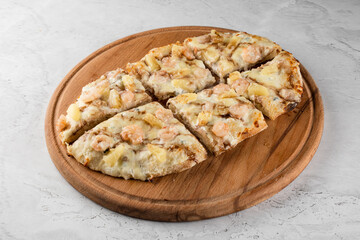 Pinsa romana with shrimps and pineapple on wooden plate on white background. Seafood scrocchiarella.