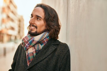 Young hispanic man smiling happy standing at the city.