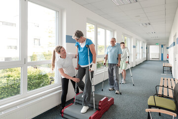 Seniors in rehabilitation learning how to walk with crutches