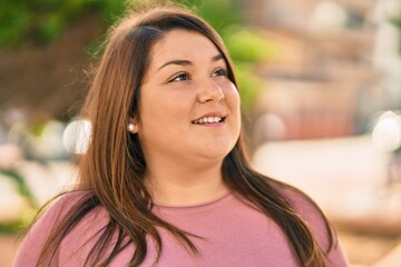 Obraz premium Young hispanic plus size woman smiling happy standing at the city.