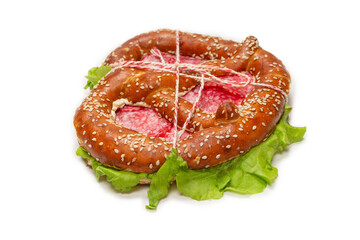 Pretzel with salami and lettuce isolated on a white background.