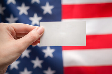 Empty card in woman hand. Copy space.  American flag background.