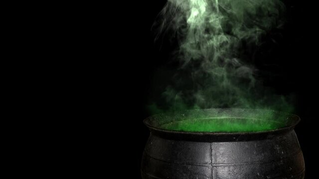 Witch Cauldron Smoking Green Close-Up 4K Loop features a metal cauldron with green glowing smoke rising-up in a loop against a black background
