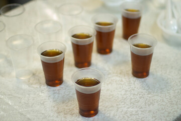 Plastic cups with tea. Tea for guests. Free distribution of hot drinks.