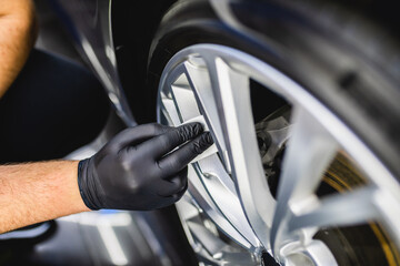 A man cleaning car, car detailing (or valeting) concept. Selective focus..