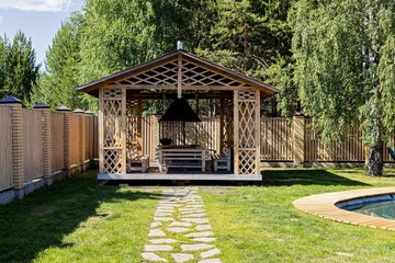 Wooden barbecue gazebo, patio area and swimming pool in backyard of country house. Ideal place for...