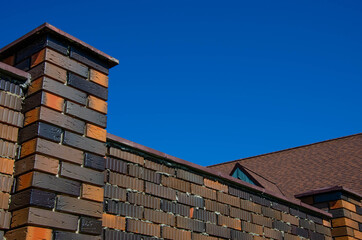 The wall is made of colored bricks. The fence is made of colored bricks.