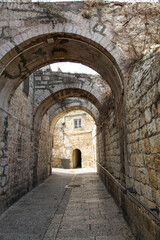 Fototapeta na wymiar Quiet arch covered stone alley in Old City Jerusalem